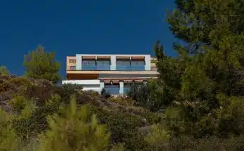 a house on top of a hill surrounded by trees
